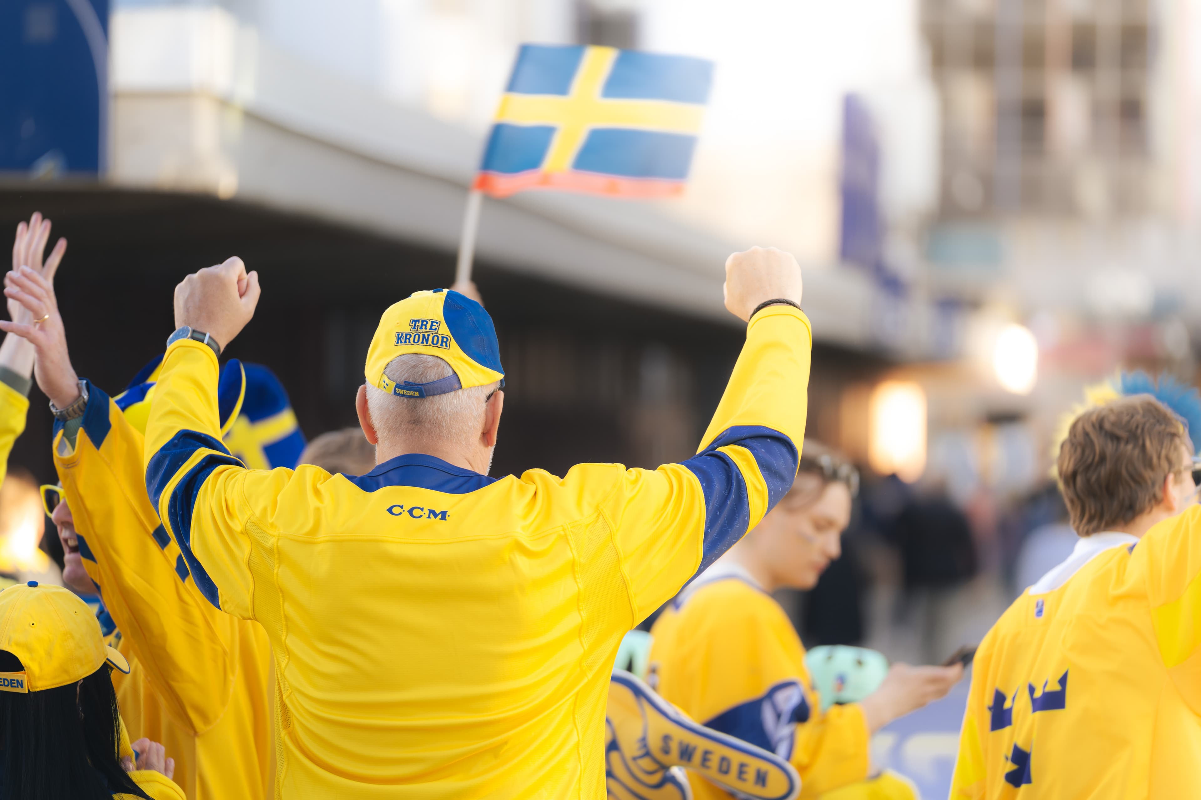 Ishockeyfans med sverigetröjor på väg in på arenan.