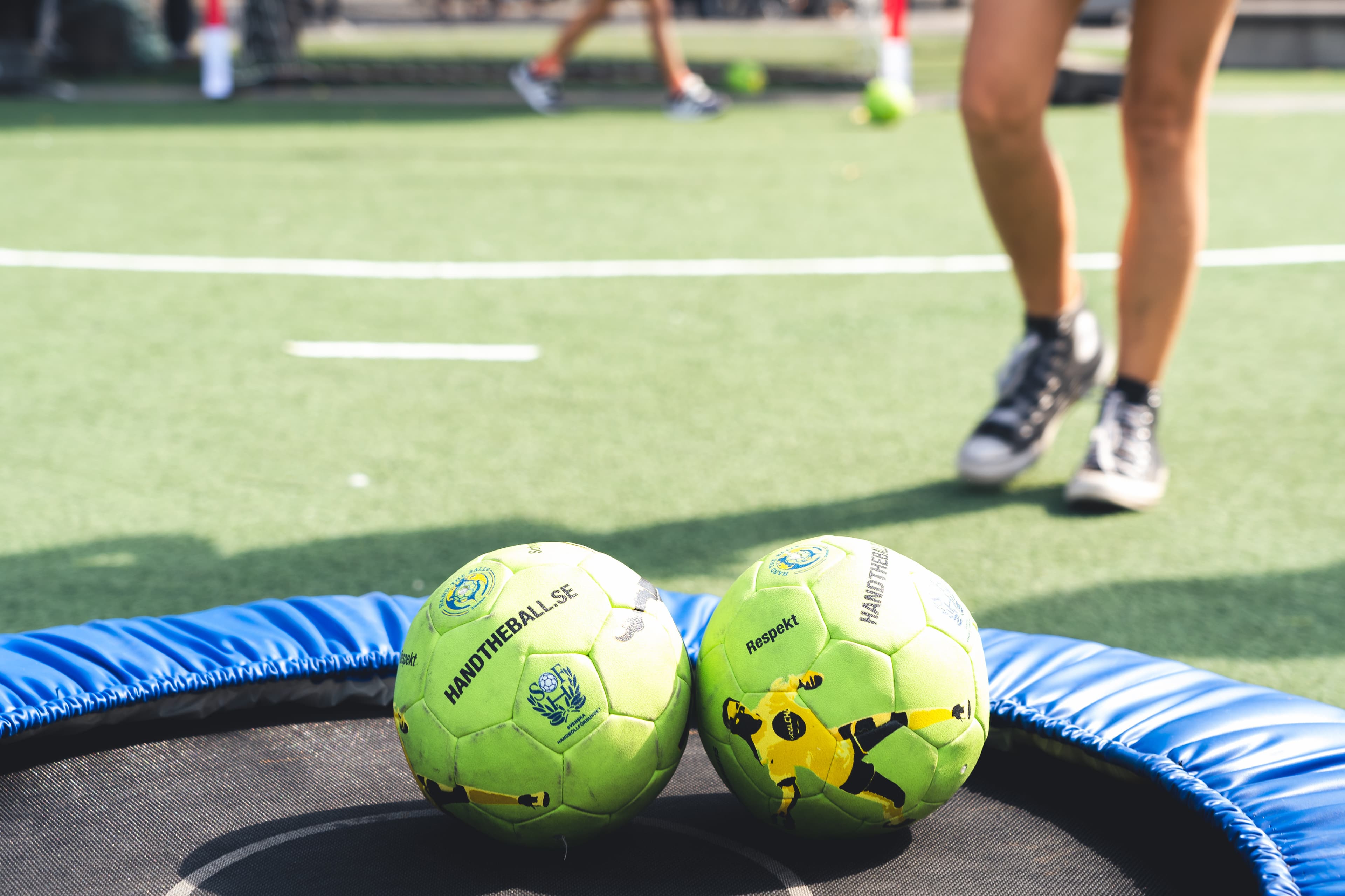Handbollar som ligger utomhus på konstgräs
