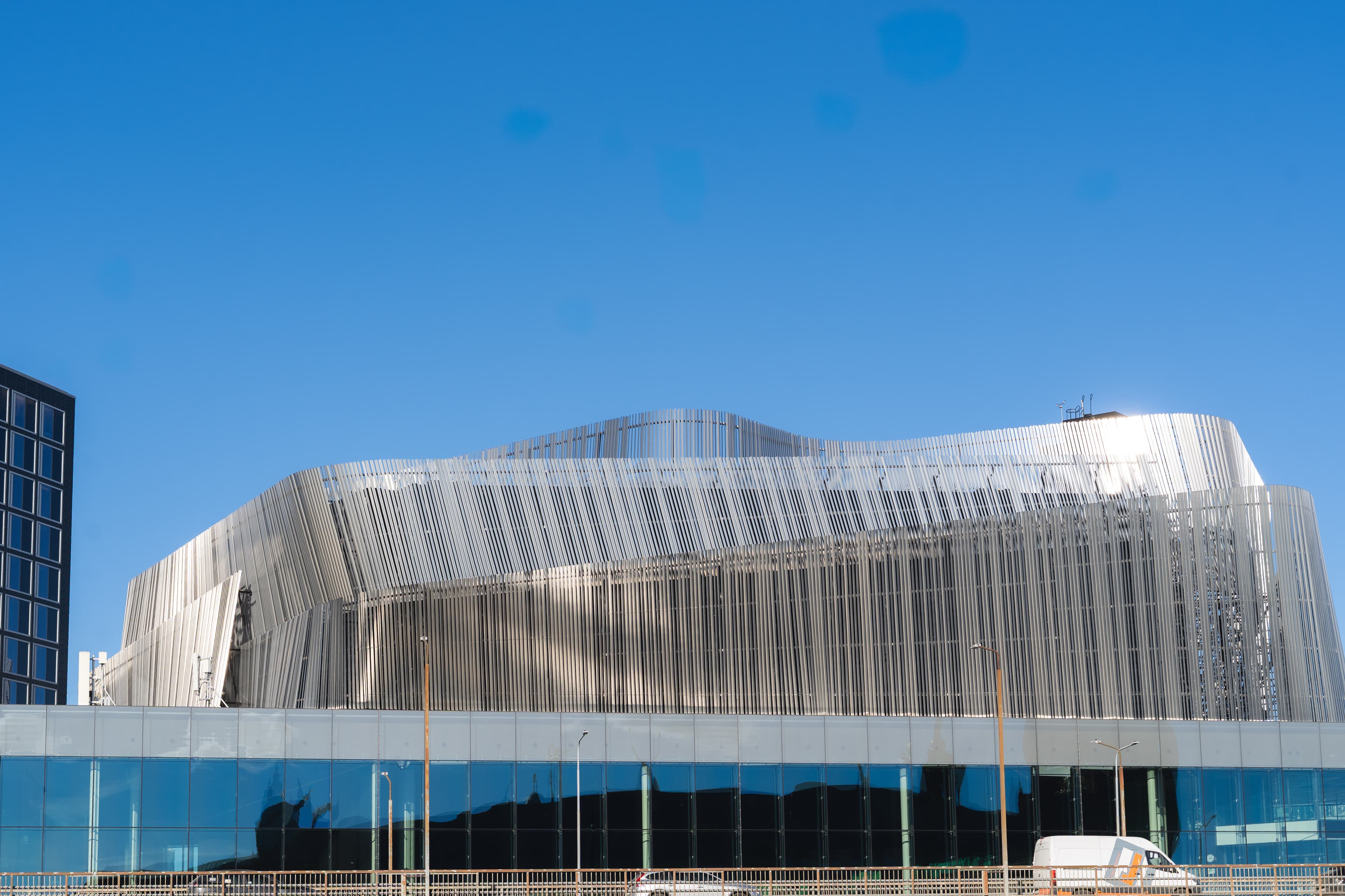 Stockholm Waterfront Congress Centre with its wave-shaped metallic façade, viewed from the outside against a clear blue sky.